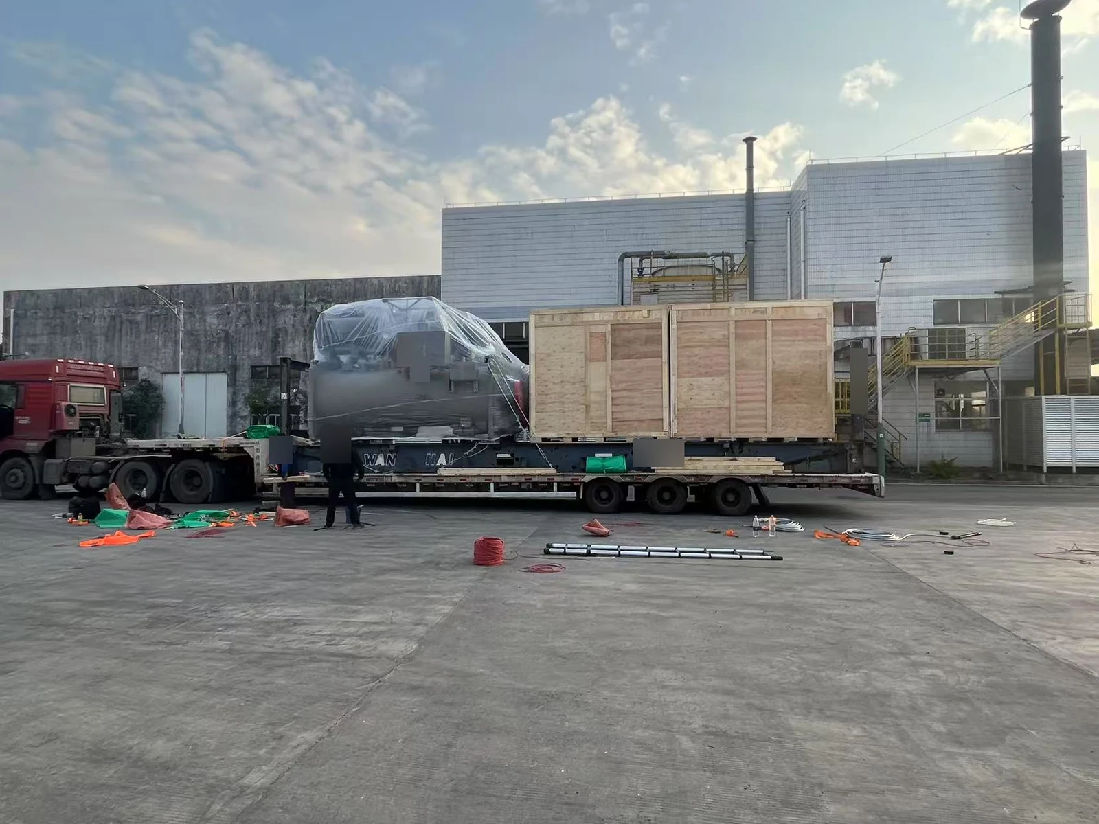 Wrapped chiller equipment and wooden shipping crates on a trailer for Thaixing Circuits, Thailand